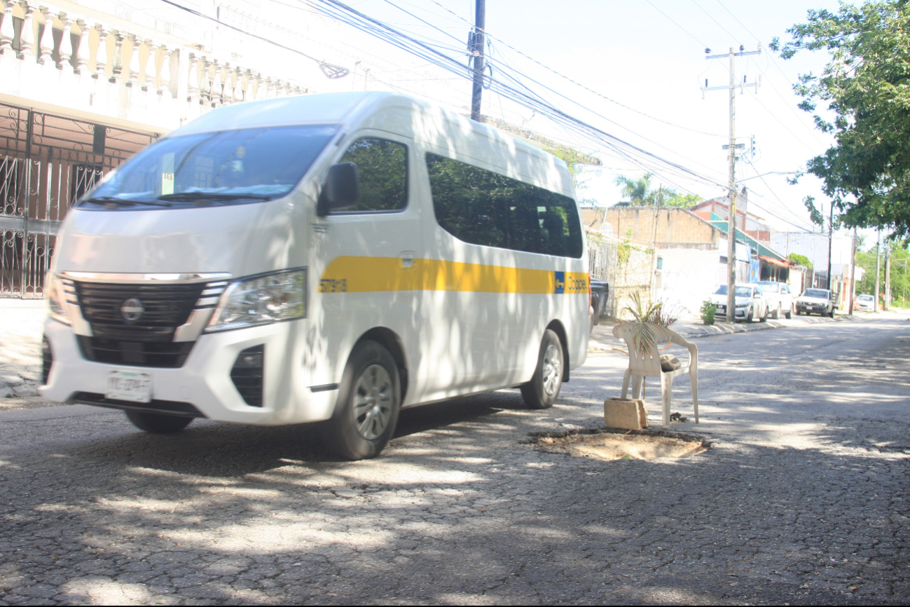 Con sillas y hojas de palmera advierten la presencia de baches en Cancún