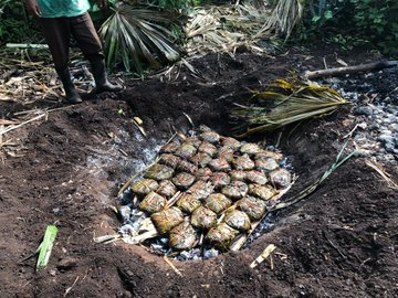 Cocinar el pibipollo en un horno de tierra le da un sabor ahumado y único, y es un proceso comunitario