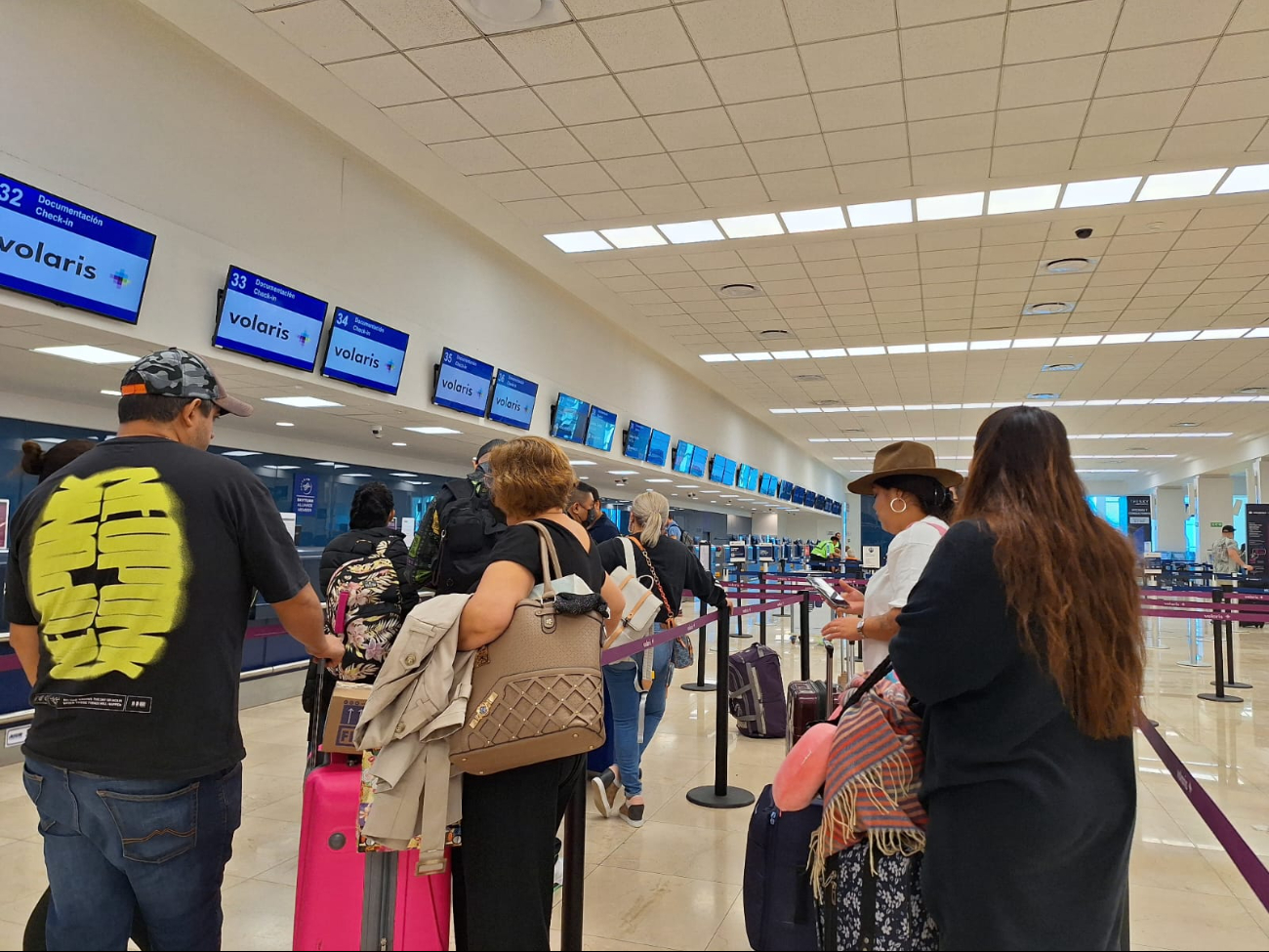 Pasajeros del aeropuerto de Mérida esperan en los mostradores de las aerolíneas