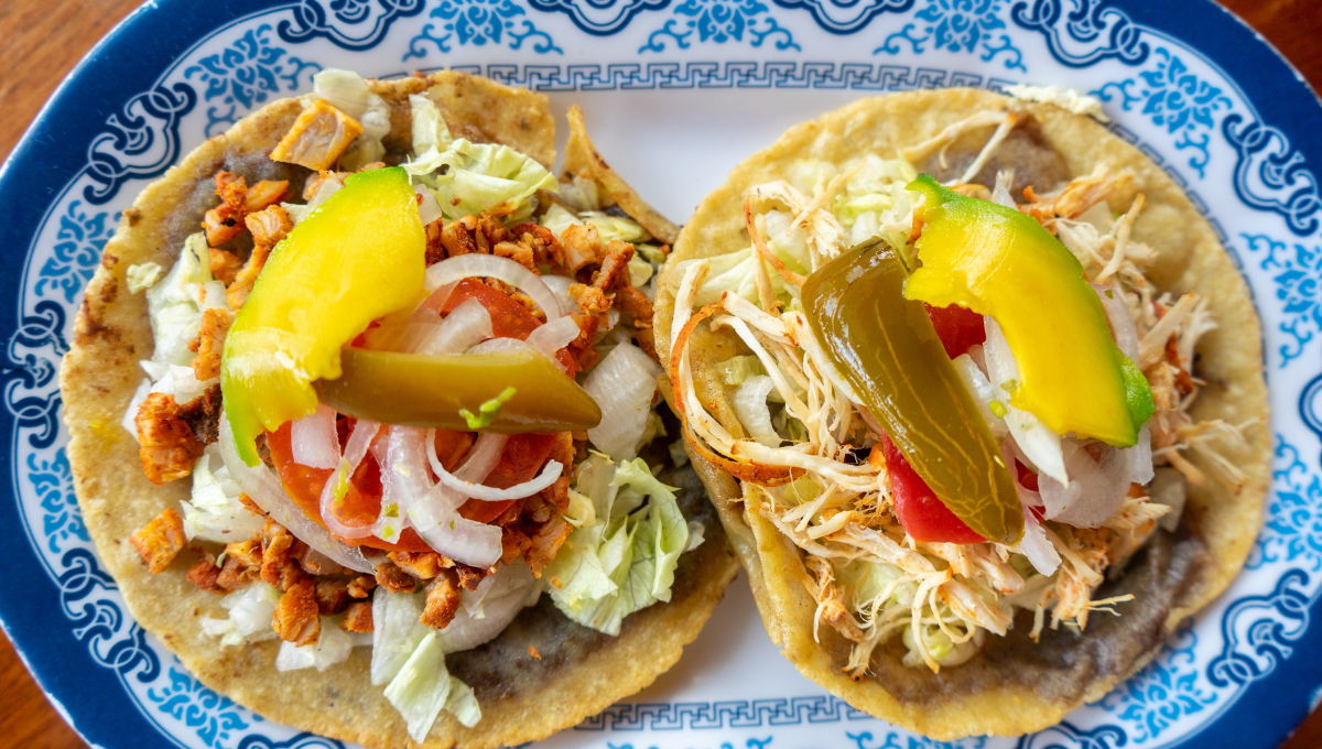 Tortillas de maíz fritas, rellenas de frijoles y cubiertas con carne, cebolla, lechuga y salsa