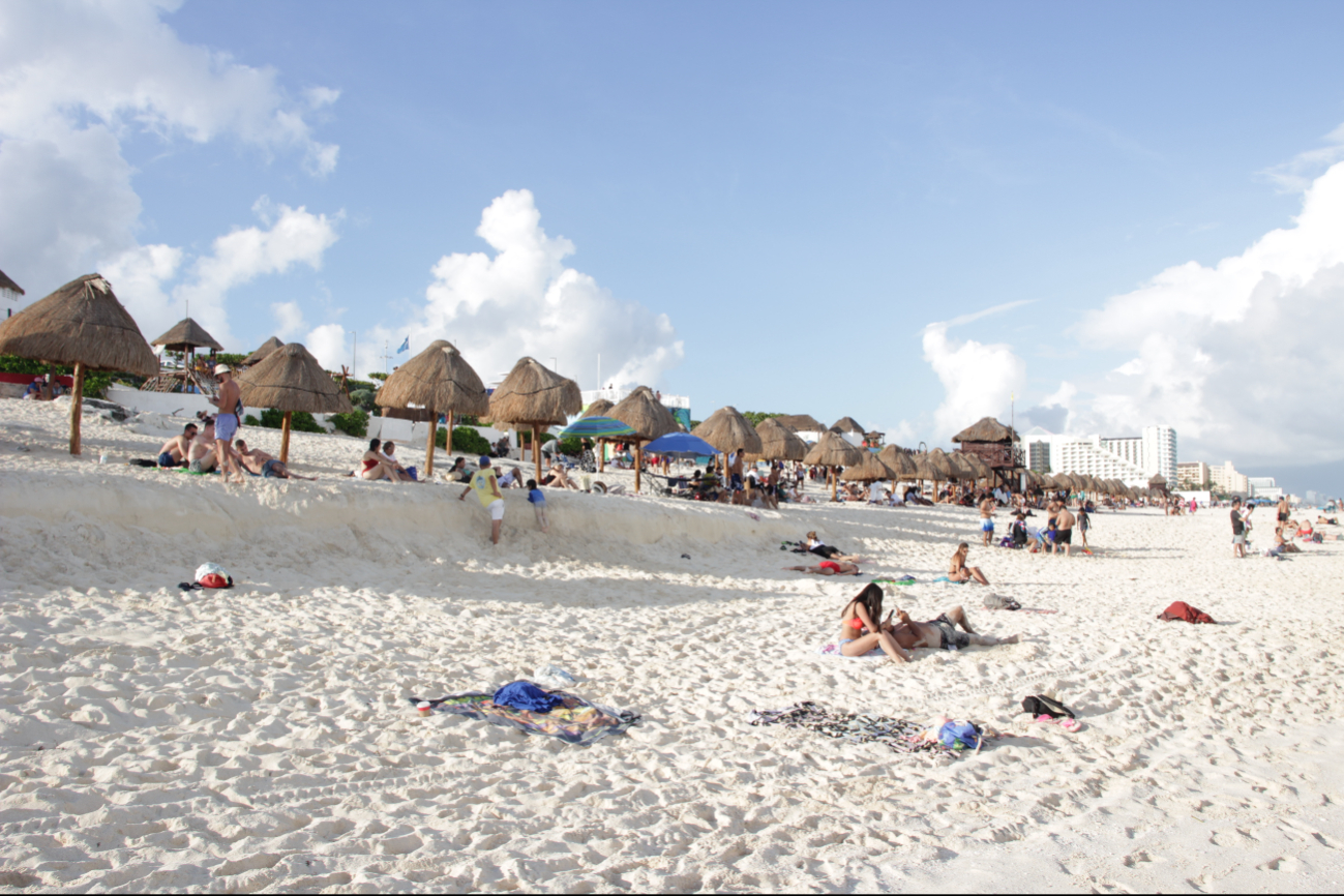 Pese al clima y las temperaturas, turistas van a las playas de la ZH de Cancún