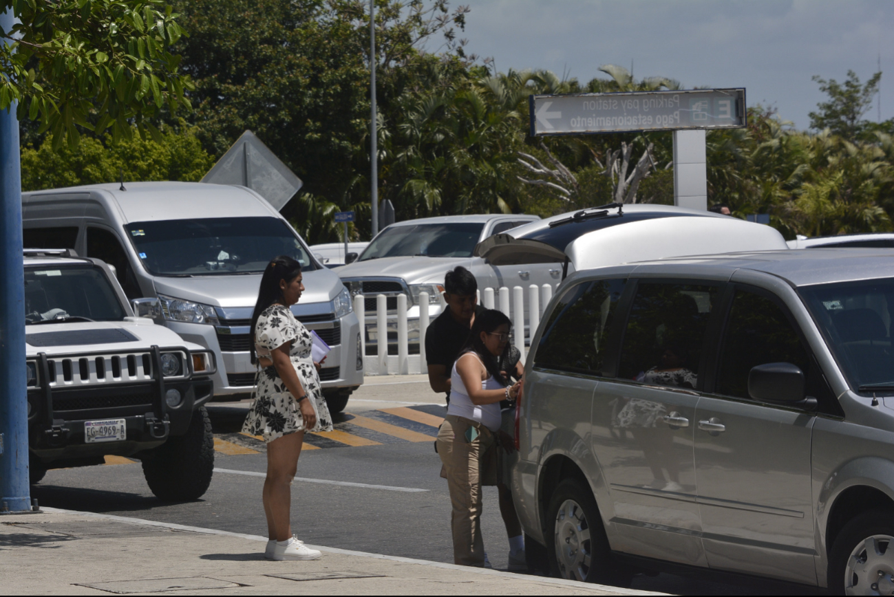 Viajeros bajan sus maletas para emprender el vuelo desde el Aeropuerto de Cancún