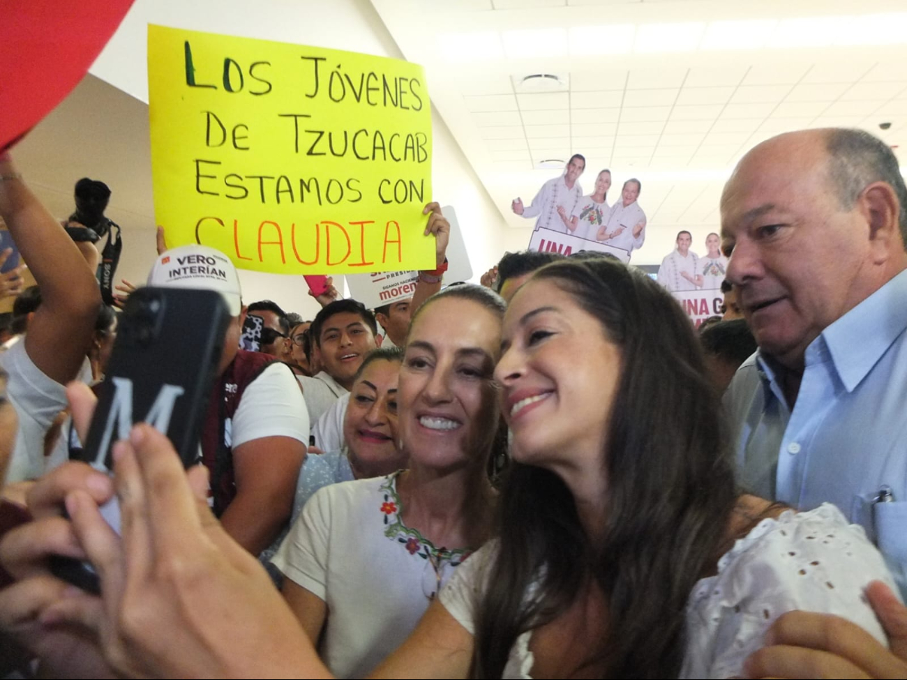 Claudia Sheinbaum posa junto a una simpatizantes en el Aeropuerto Internacional de Mérida