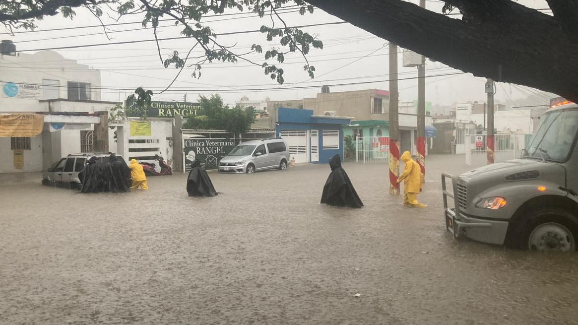 Marinos remueven auto varado por las lluvias