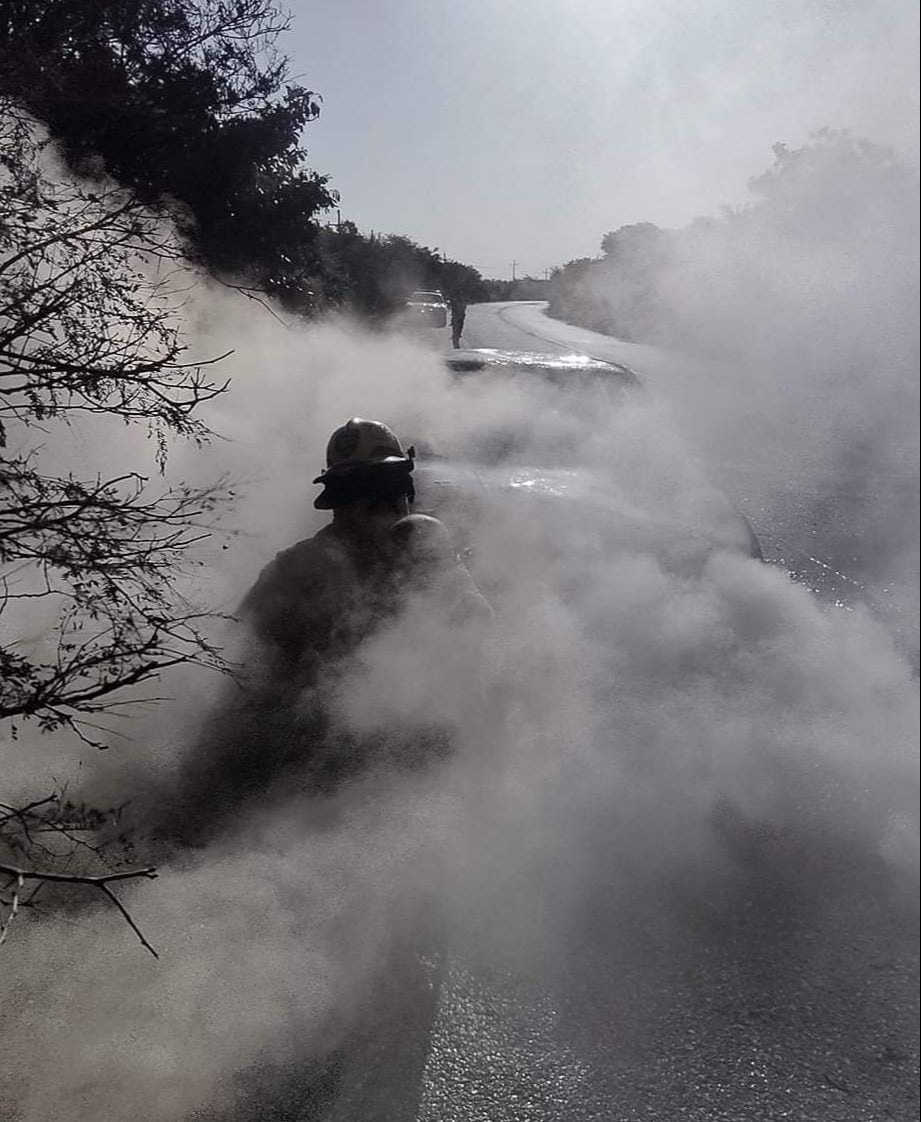 Bomberos tratan de apagar el incendio en la carretera