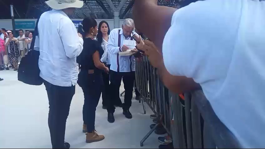 AMLO se detuvo para firmar autógrafos