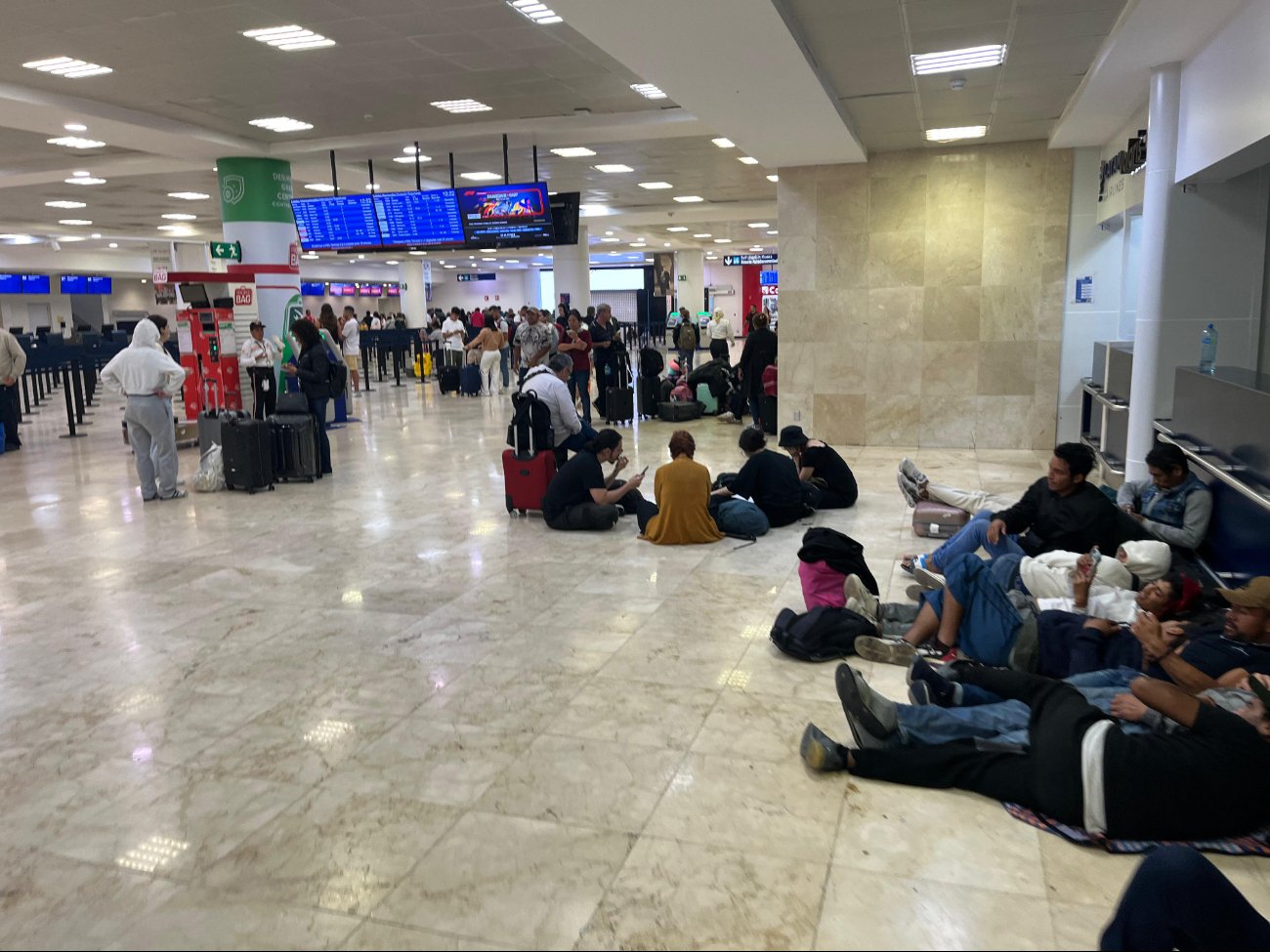 Hay decenas de pasajeros esperando en el aeropuerto de Cancún