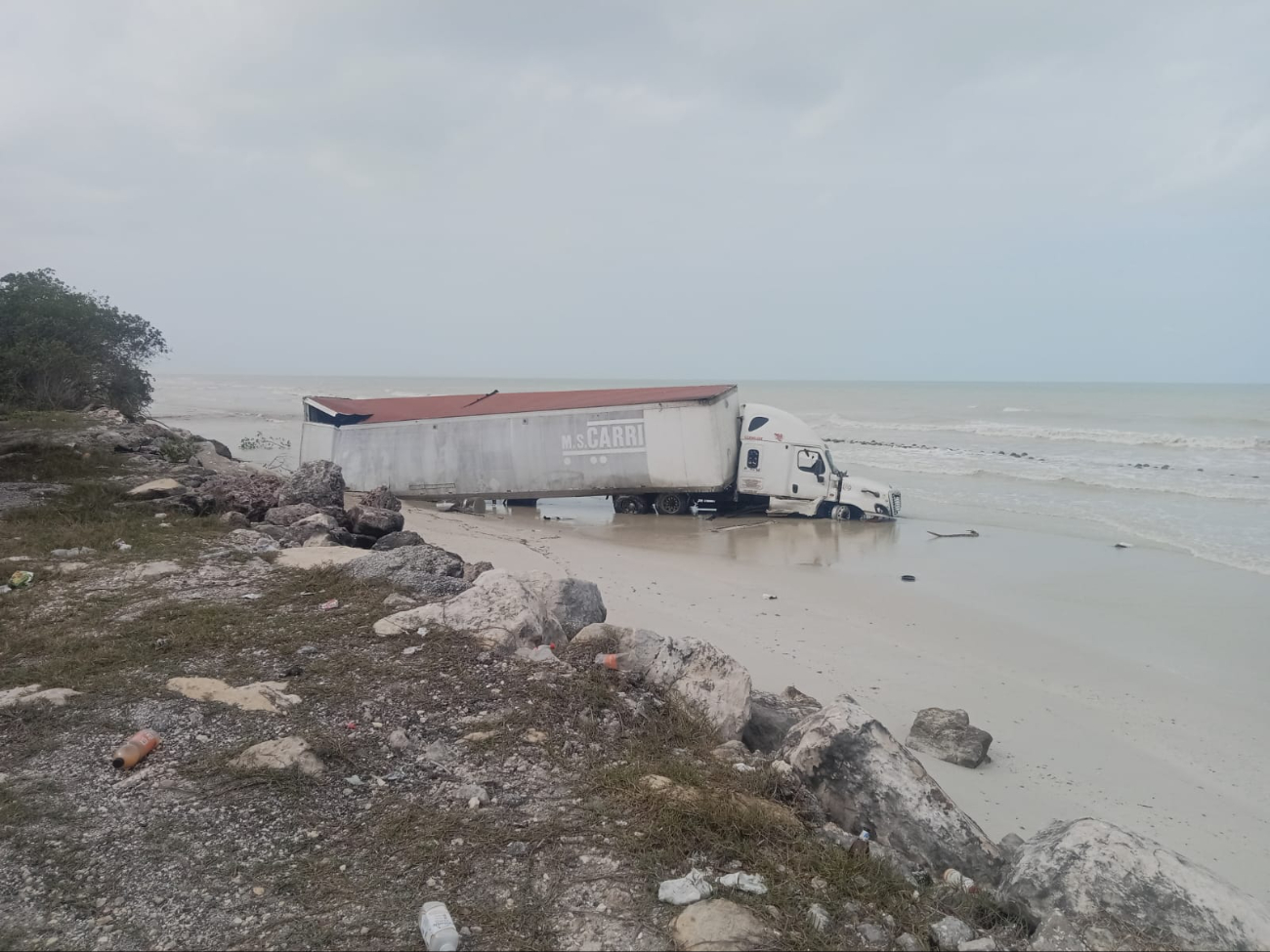 Un tráiler termina en la orilla del mar desdprendido de un accidente víal.