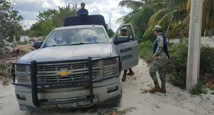 Agentes federales atienden el reporte de turistas frente a un hotel, en la playa de Telchac Puerto