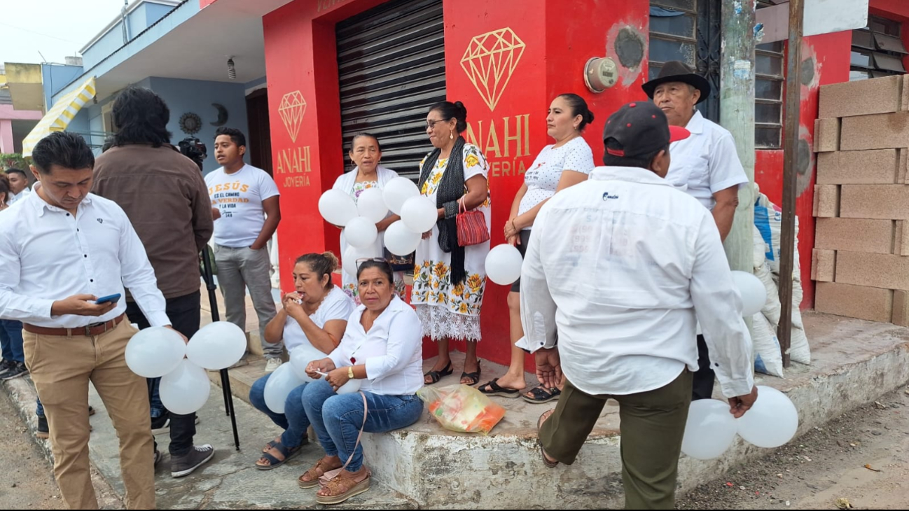 Habitantes de Tekit visten de blanco o portan globos en la marcha