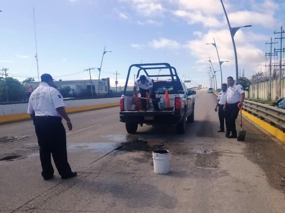 Policías tapan baches en boulevard de Playa del Carmen