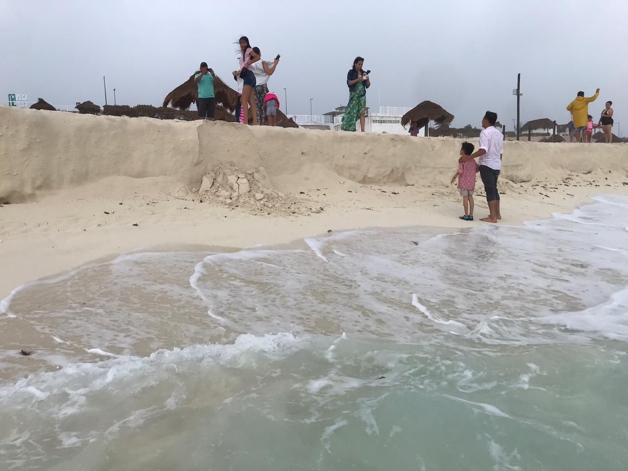 Pese a lluvias, turistas disfrutan de playas en Cancún