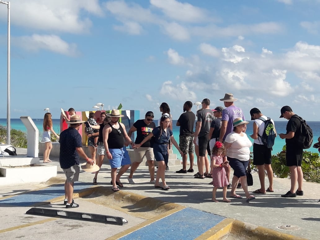 Turistas y locales, en su mayoría sin tapabocas, realizaron una larga fila para tomarse la foto del recuerdo en el parador turístico de Cancún