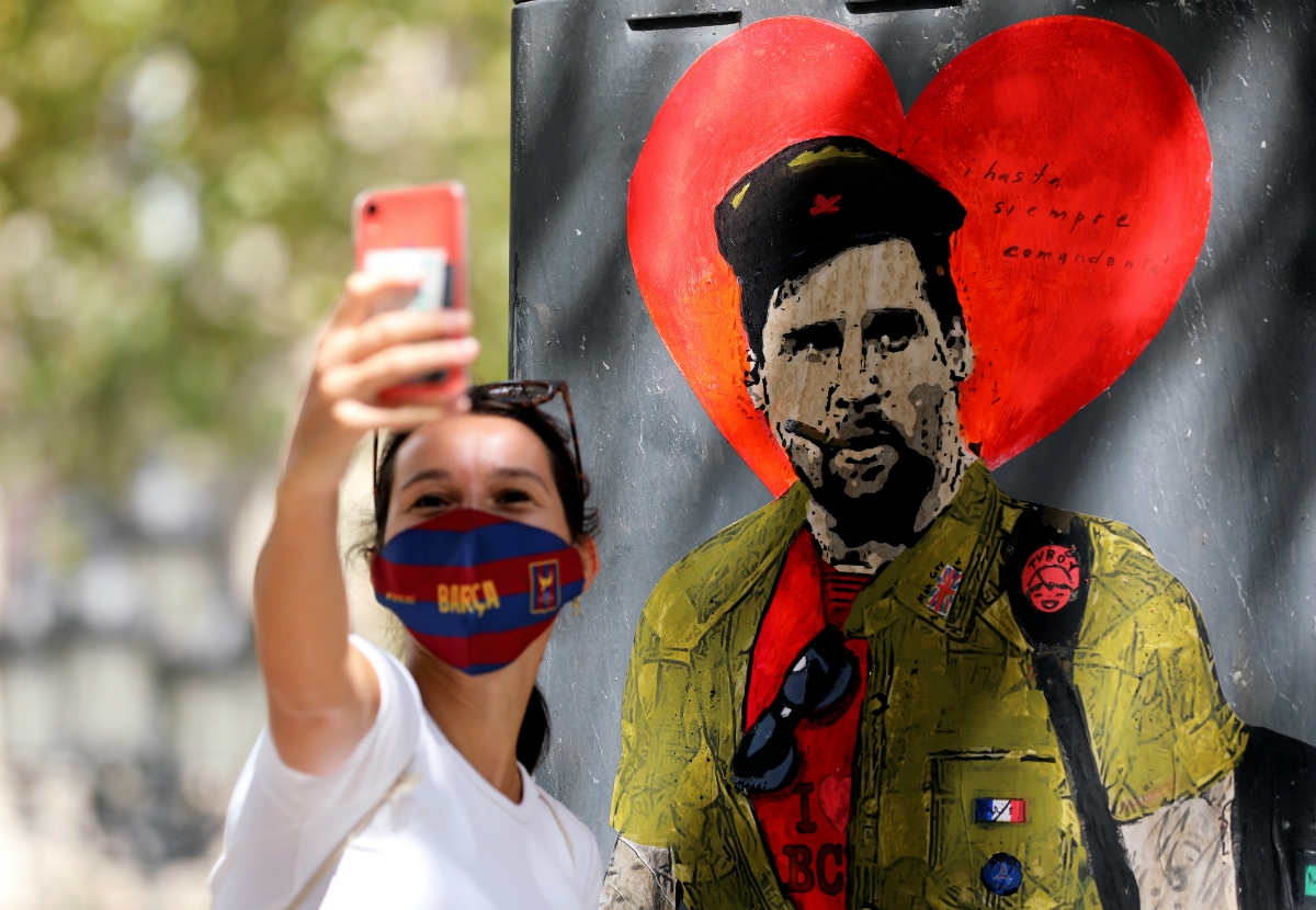 Una mujer se toma una selfie con la imagen de Messi como el Che Guevara (Reuters)