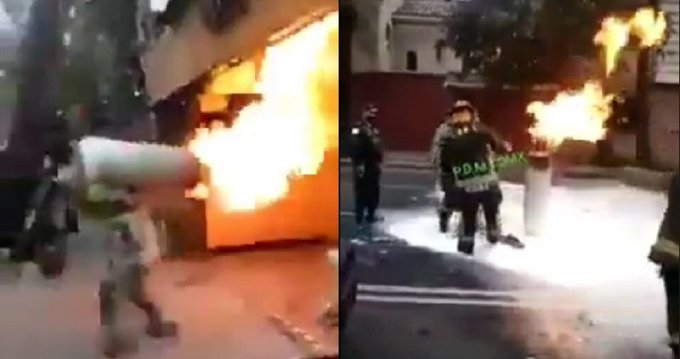 El bombero salió el inmueble con el tanque de gas en los hombros