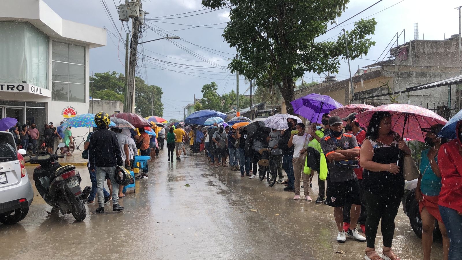 Los cancunenses rezagados permanecieron enfilados aún con la lluvia para recibir su vacuna anticovid de Pfizer