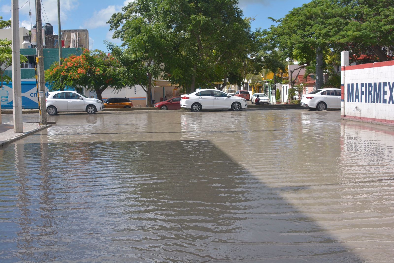 Más de una docena de baches se encuentran abajo del agua en esta calle inundada