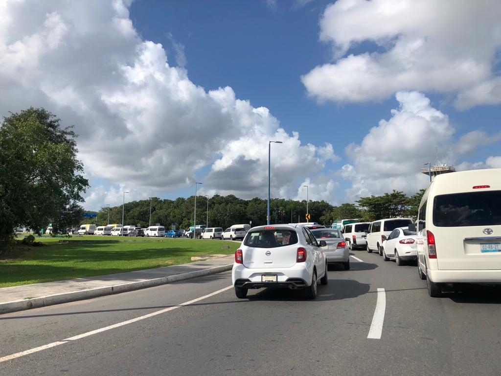 Se formó una fila de vehículos que esperan entrar a las terminales del Aeropuerto de Cancún