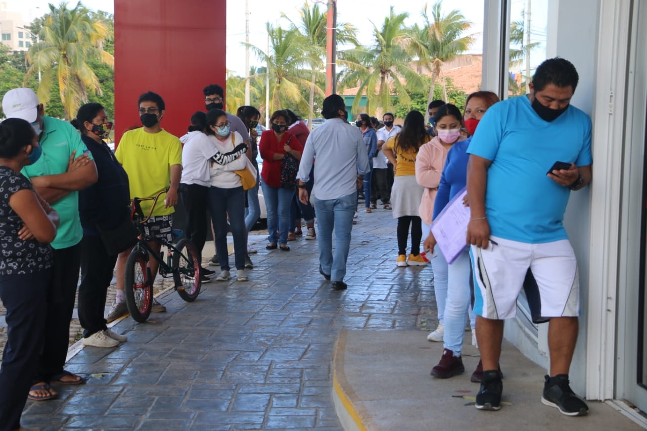 Sin respetar sana distancia, personas hacen fila en banco de Cancún