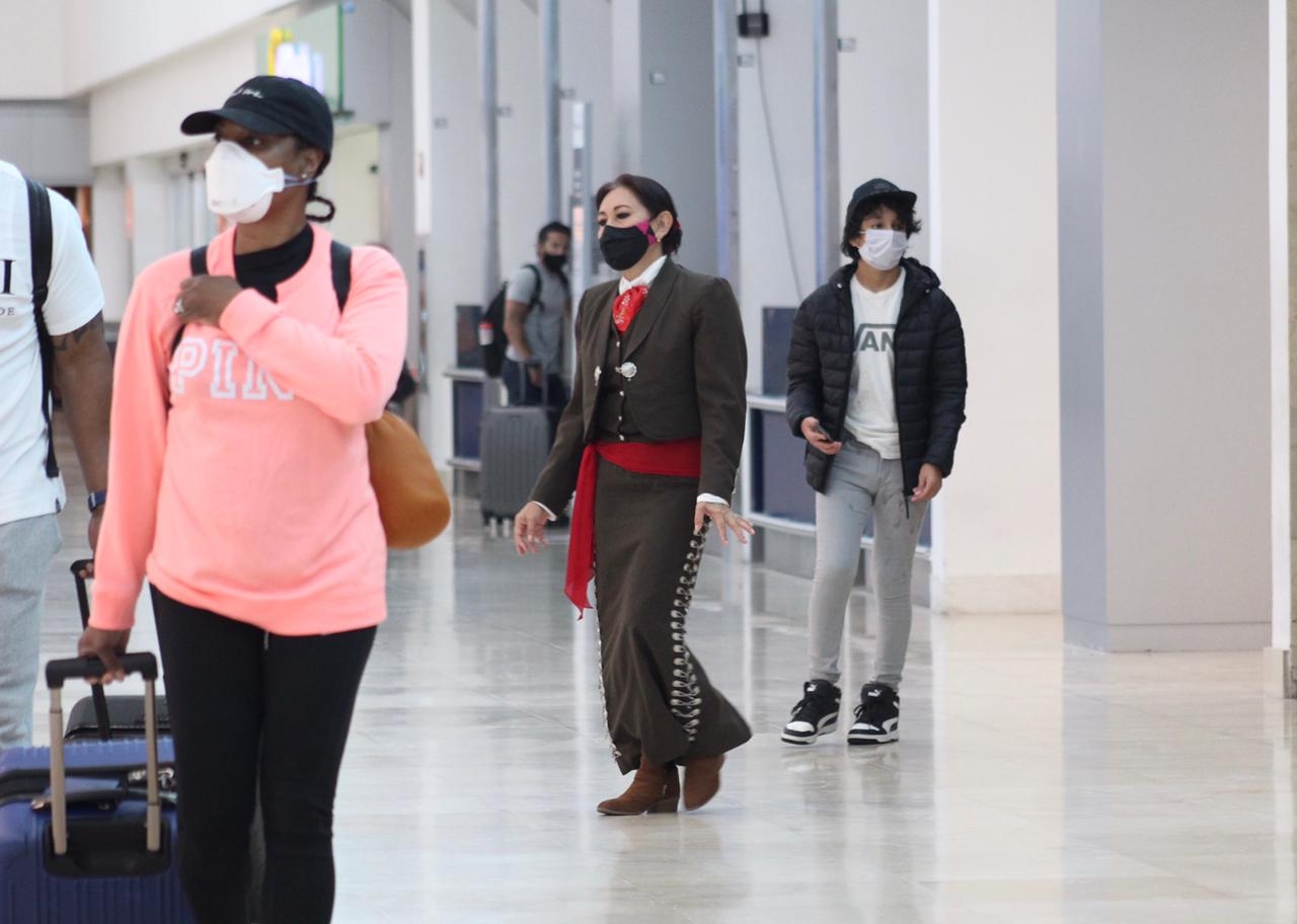 Mujer vestida de mariachi roba miradas en el aeropuerto de Cancún