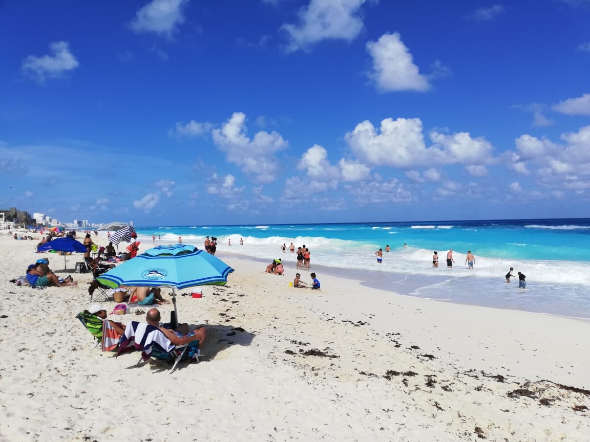 cancunenses disfrutan de la playa 
