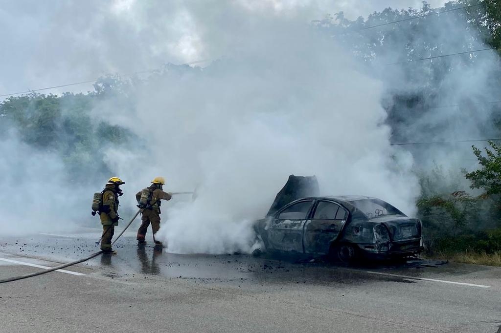 Bomberos de playa del Carmen apagando el fuego en el vehículo