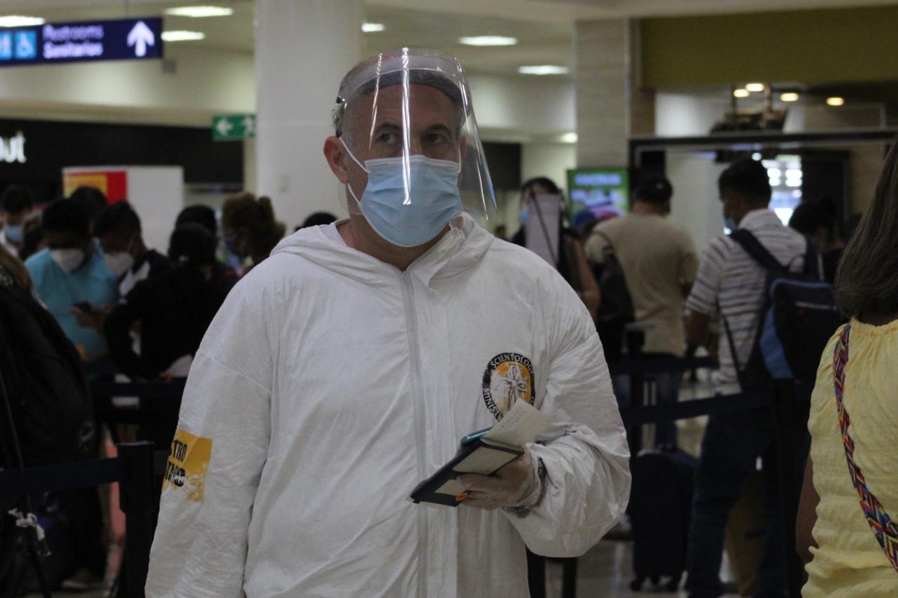 Ministro religioso pasea en el aeropuerto de Cancún con inusual traje contra COVID-19