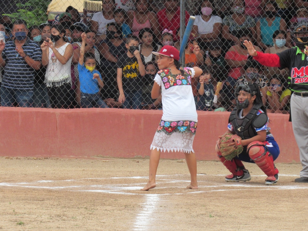 Descalzas y vistiendo atuendos tradicionales mayas presentaron un  juego de softbol