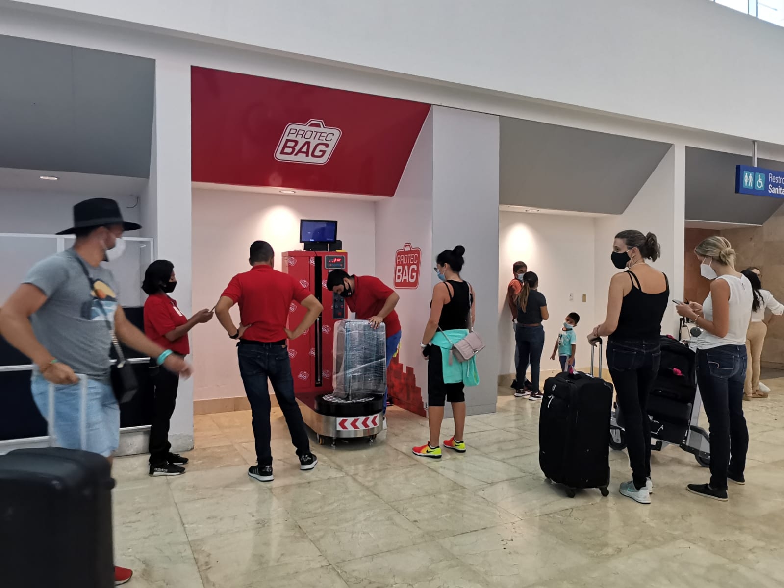 Usuarios protegen sus maletas con 'vitafilm' en el aeropuerto de Cancún