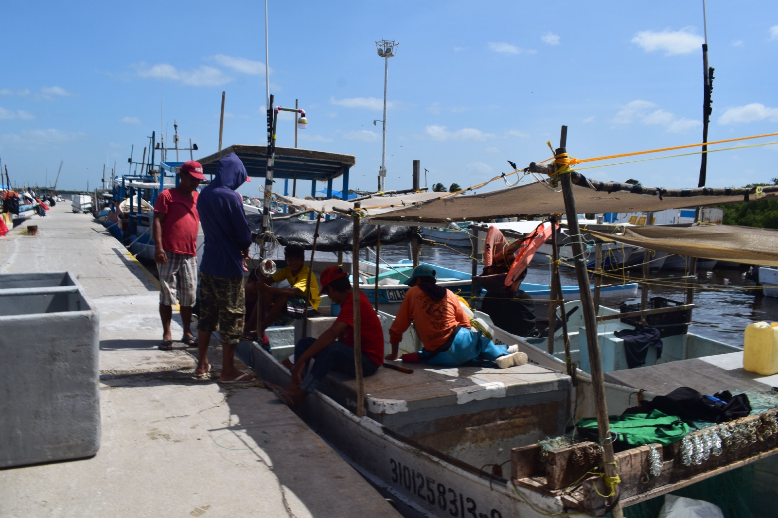 Pescadores alistan sus naves para salir a la mar tras varios días de permanecer en el puerto de embarque en Progreso