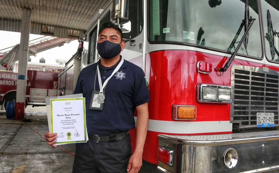 Hector Pimentel posa con su reconocimiento de lealtad y sacrificio por el rescate de Spike y Spay