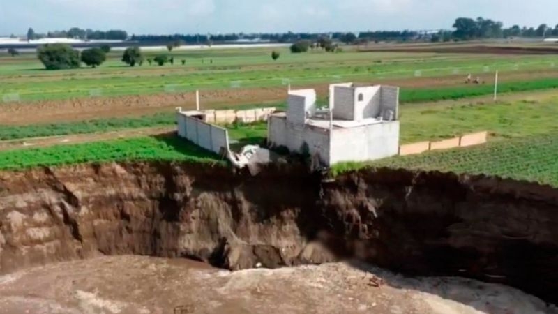 Socavón en Puebla aumenta su tamaño y 'se traga' la barda de una vivienda cercana