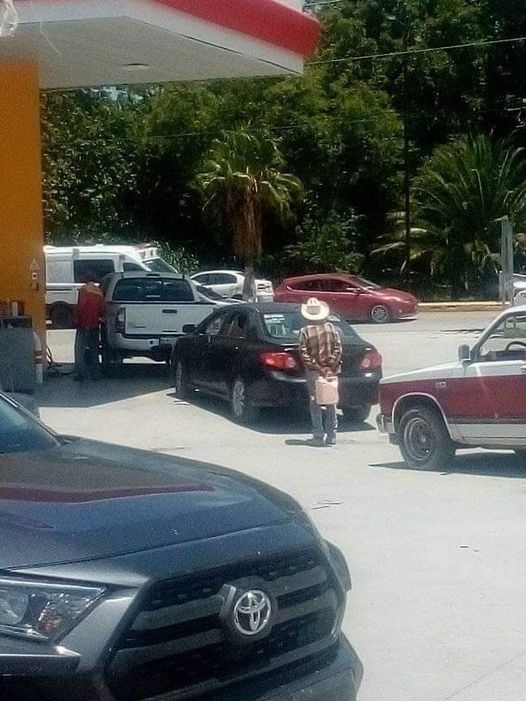 A pesar del sol, el hombre esperaba su turno tras dos autos que cargaban gasolina