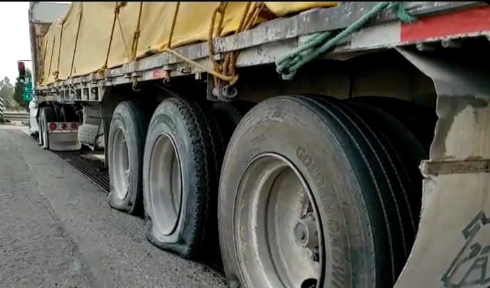 El camión de carga ya no pudo avanzar luego de que el sistema le ponchó 10 llantas. Foto: Captura de Pantalla