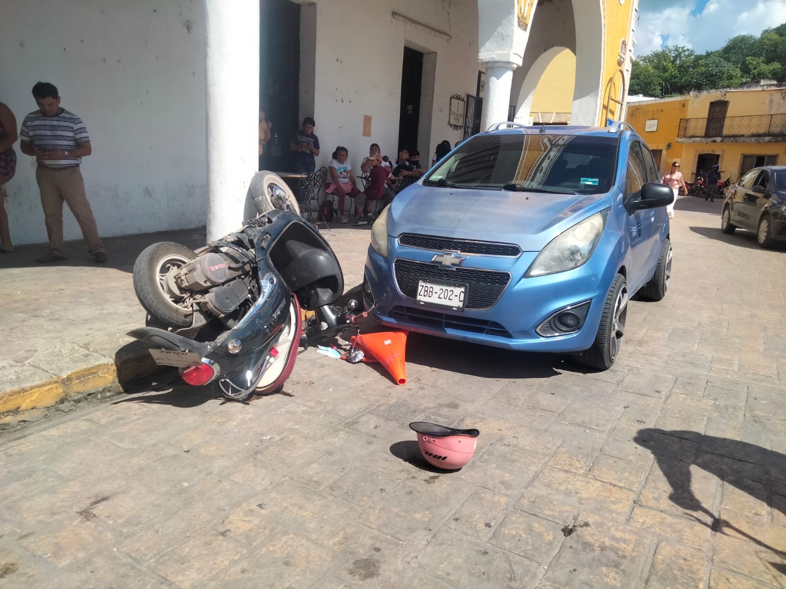 Mujer pierde el control de su motocicleta y choca contra un auto en el Centro de Izamal