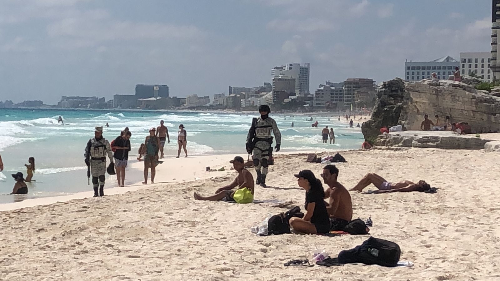 Los salvavidas a lo lejos cuidan que los turistas respeten los límites para poder nadar