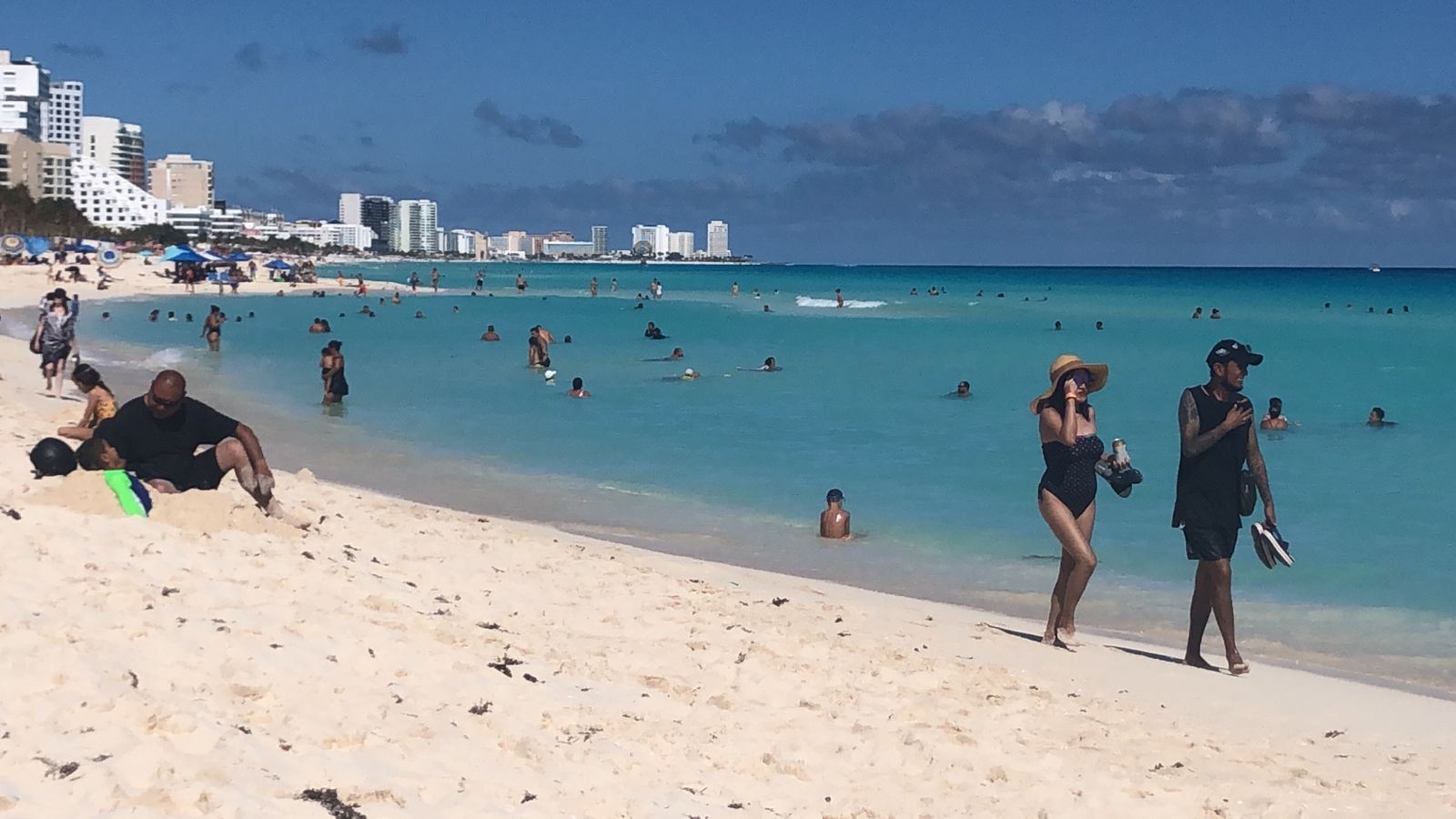 Con sombreros y lentes, bañistas disfrutan del arenal