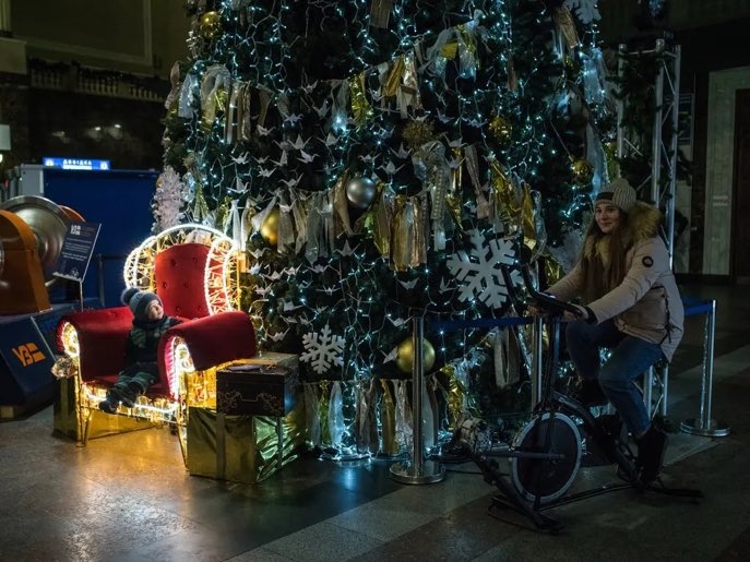 En Kiev una mujer pedaleaba un generador de bicicleta para alumbrar un árbol de Navidad