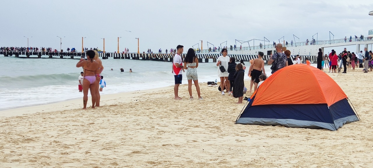 Turistas de la CDMX desafían el Frente Frío 19 en Playa del Carmen