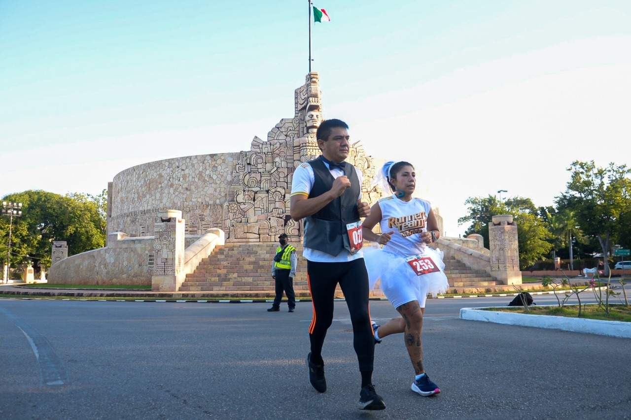 Vestidos de novios, pareja corre sobre Paseo de Montejo en Mérida