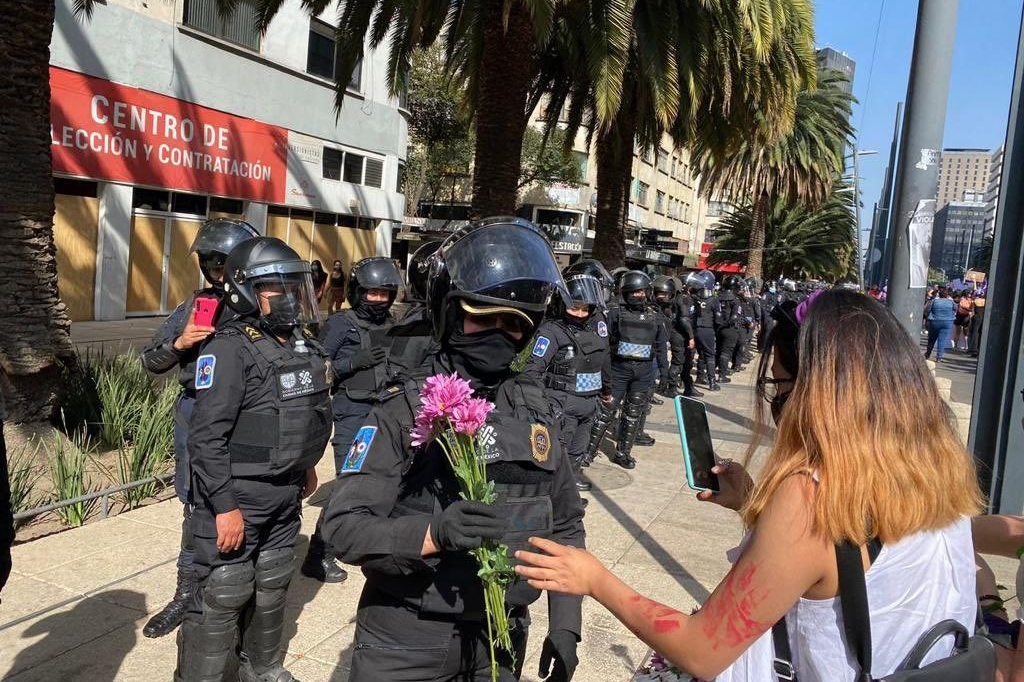 Las policías recibieron rosas por parte de las manifestantes. Foto: Twitter @Minnie_Mousse1
