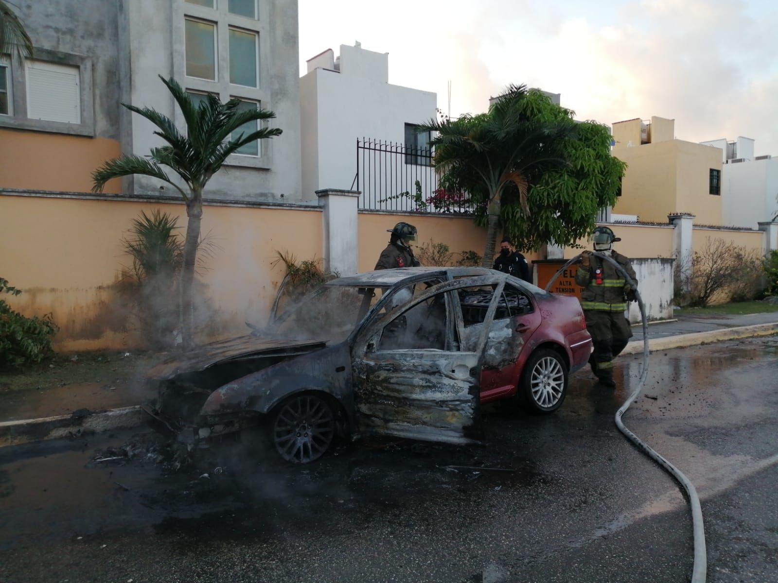 El fuego que se generó en la zona del motor del automóvil tipo Jetta en Cancún, según por un cortocircuito