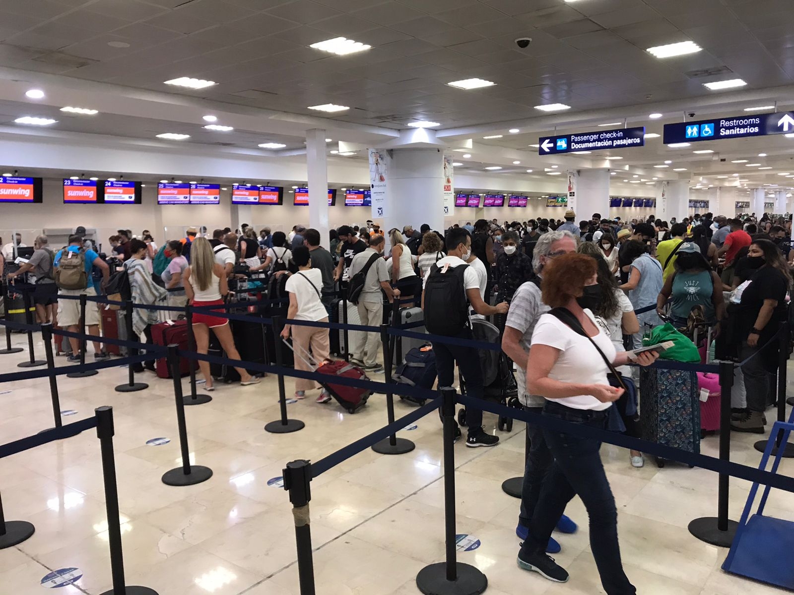 Los pasajeros en el aeropuerto de Cancún hacen filas para documentar su equipaje o preguntar a qué hora saldrá su vuelo, en caso de que tuvieise atrasos