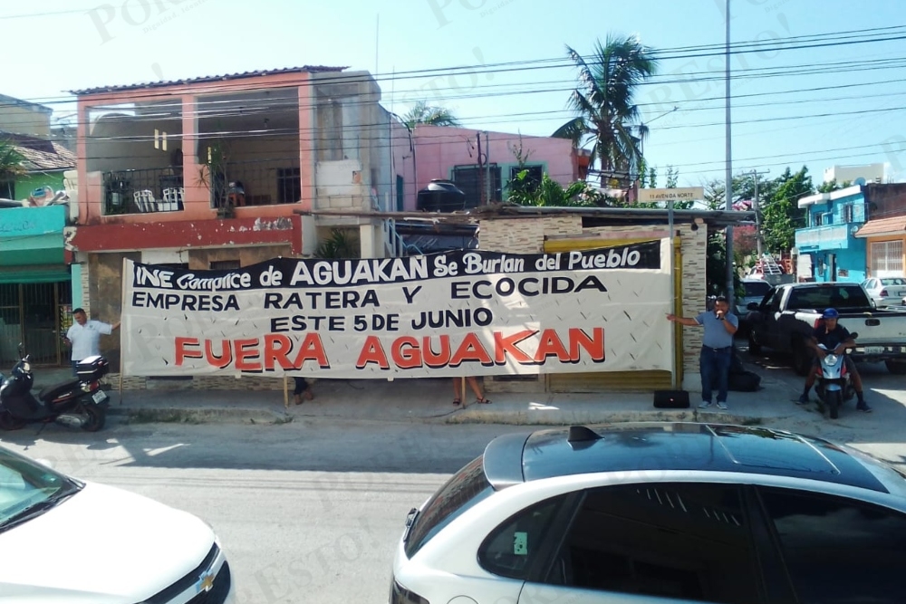 Una manta fue extendida afuera de la sede del INE en Playa del Carmen por manifestantes para mostrar su rechazo a Aguakan