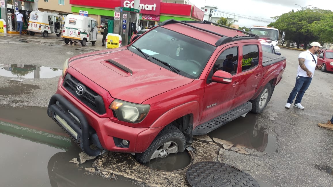 La camioneta resultó con daños menores tras caer en el registro, por lo que su dueño llamó a una grúa en Playa del Carmen para sacar el vehículo