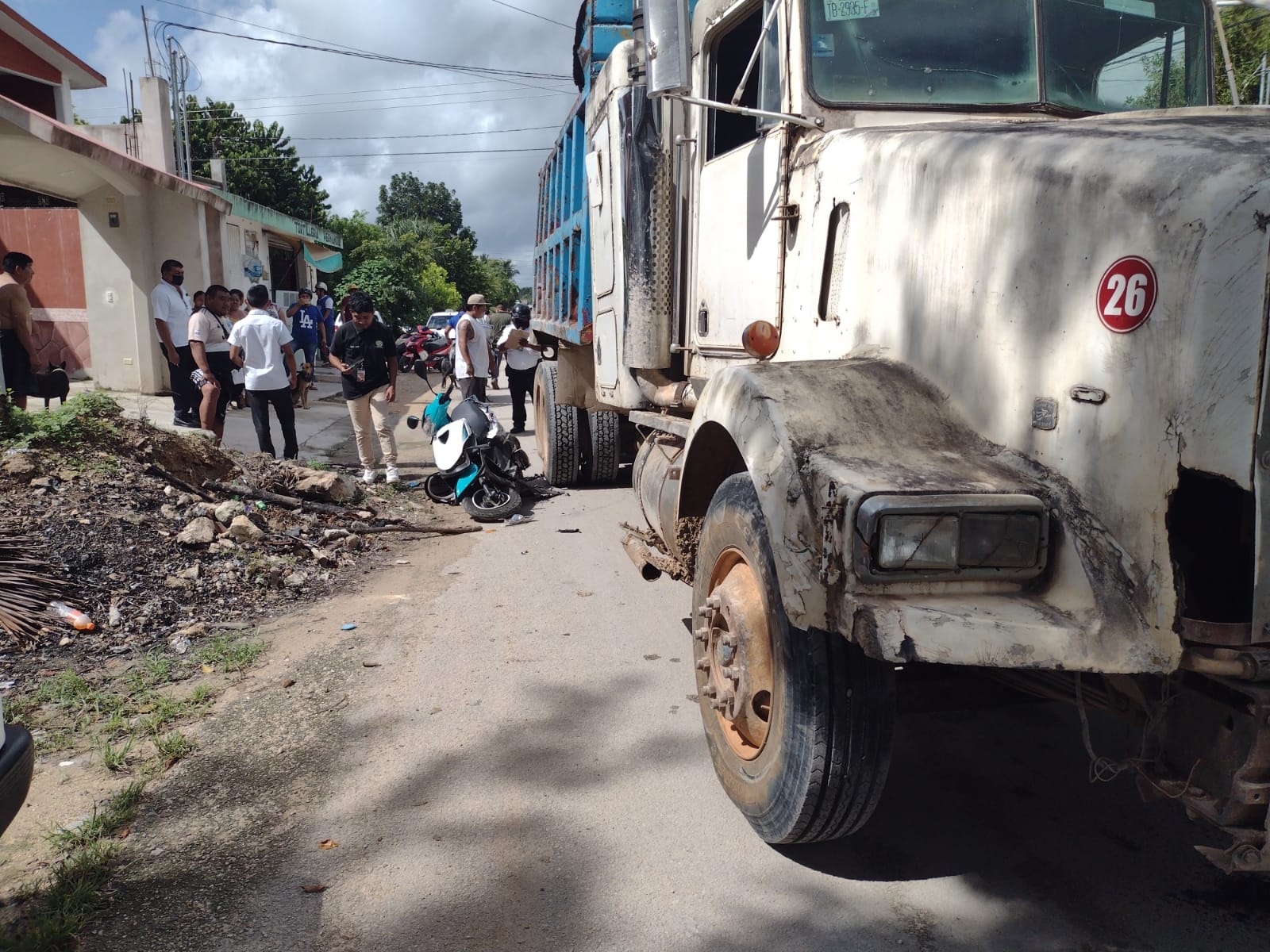 La motocicleta de la esposa del volquetero quedó dañada tras el accidente en Carrillo Puerto, donde el conductor de la pesada unidad no se percató que su cónyuge salía al mismo tiempo que él