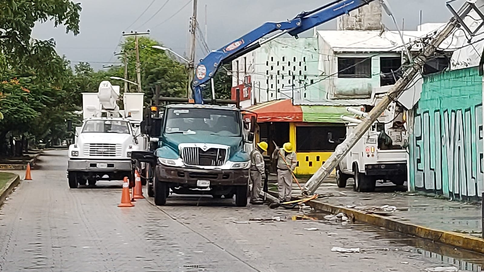 El poste caído en Cancún fue levantado con una grúa, para que el personal de la CFE iniciara las labores de reconexión de la energía eléctrica en la Supermanzana 29