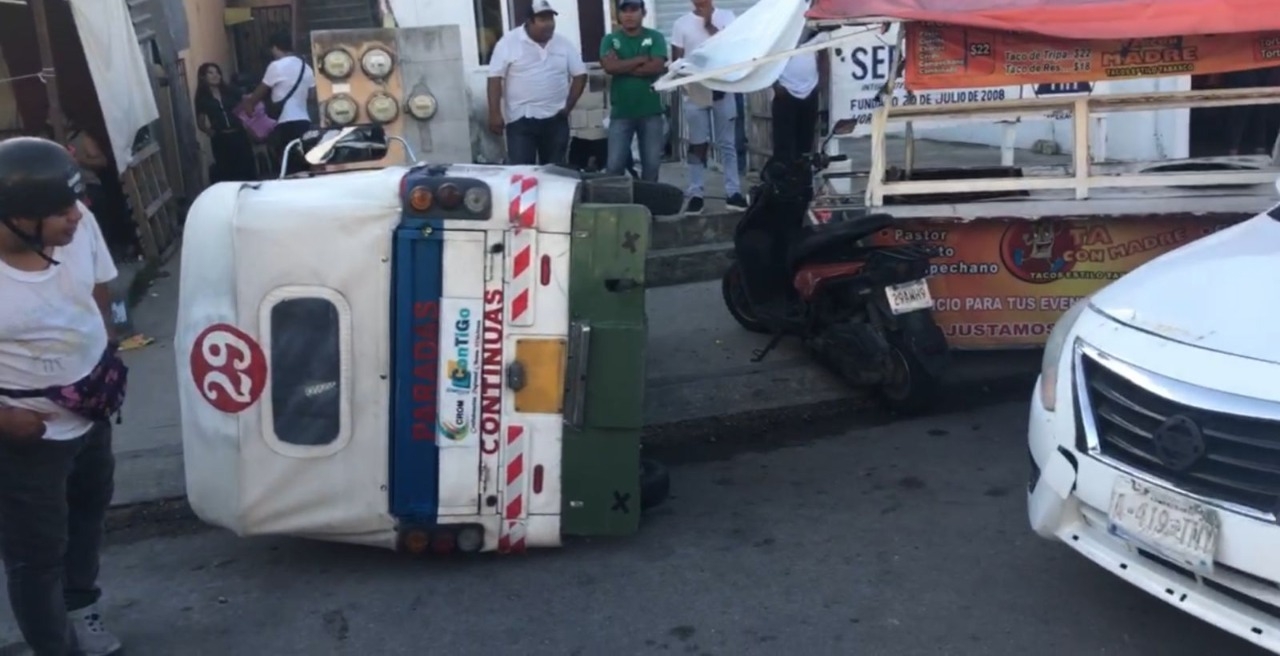 La unidad de mototaxi rotulada con el número 29 quedó de costado junto a un puesto ambulante luego de ser impactado por un conductor en Playa del Carmen