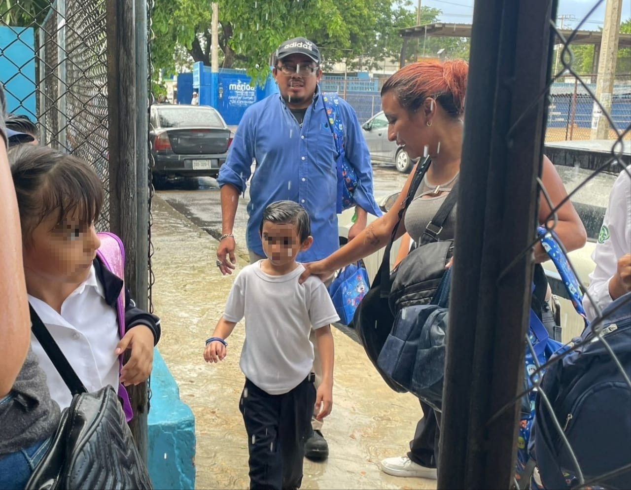 Los padres esperaron la entrada de sus hijos a pesar de las fuerte lluvia mañanera